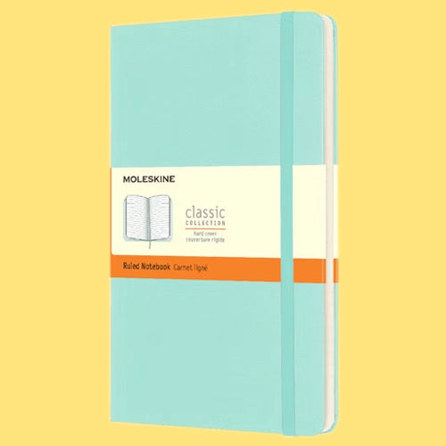 Una libreta Moleskine cerrada de tapa dura color turquesa con una banda que dice "Classic Collection Ruled Notebook".