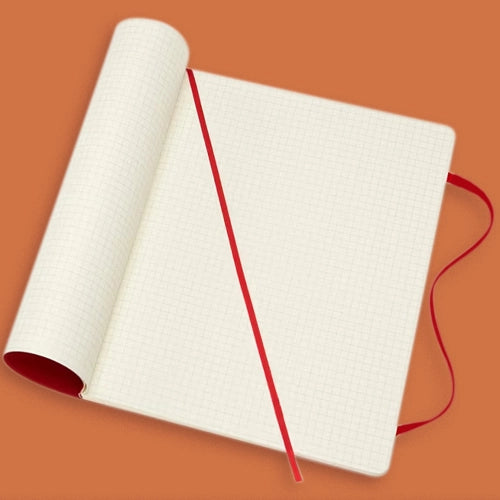 Una libreta abierta con hojas cuadriculadas de color crema y una cinta separadora roja.